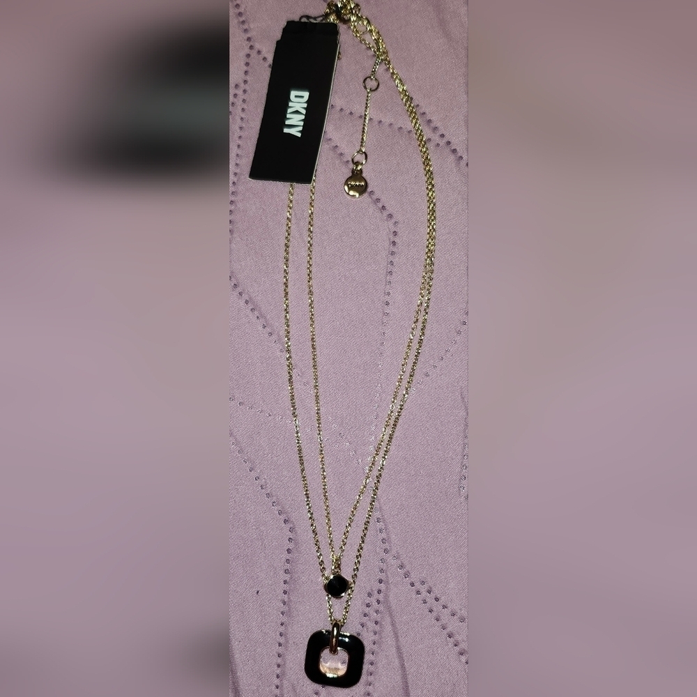 DKNY gold-tone layered necklace with a black square pendant and a tag.